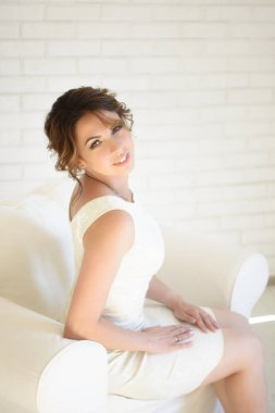 Beyaz elbise ve parlak oda siyah saçlı güzel kız