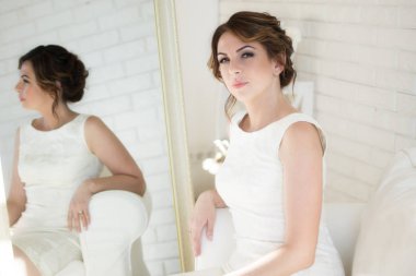 Beyaz elbise ve parlak oda siyah saçlı güzel kız