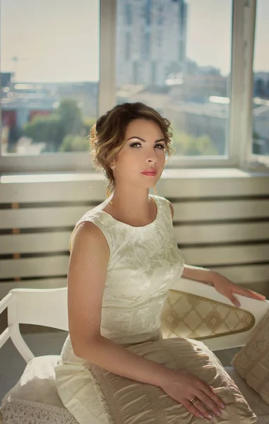 Gyönyörű lány Sötét haja a fehér ruha és világos szoba — Stock Fotó