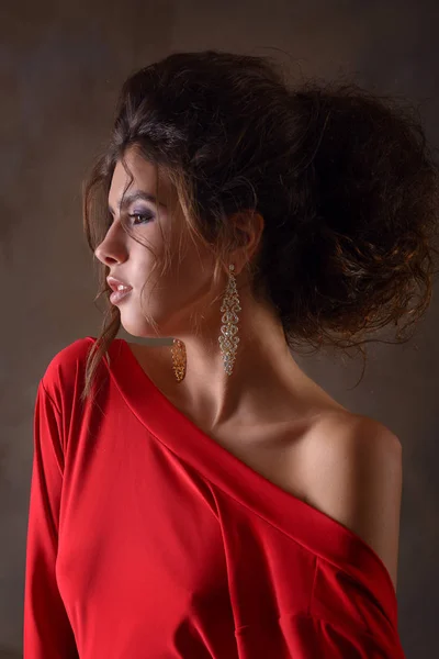 Modelo de menina jovem e esbelta com cabelo escuro e em um vestido de noite vermelho — Fotografia de Stock