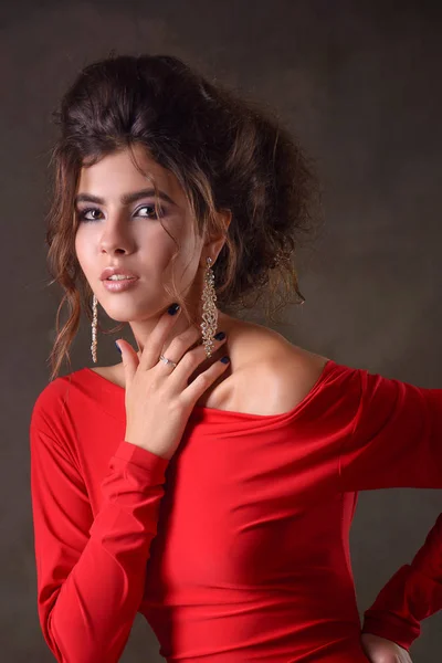 Modelo de menina jovem e esbelta com cabelo escuro e em um vestido de noite vermelho — Fotografia de Stock