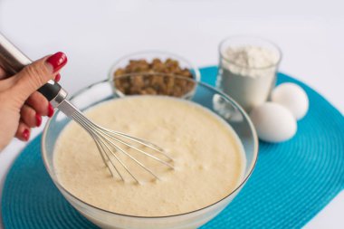 cam kase hamur ve ürünü ayarla bir kadın el çırpma teli ile