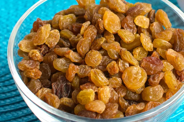 Mavi peçete üzerinde şeffaf bir kase kuru üzüm