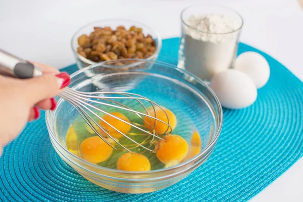 tavuk yumurtası ve fırçalamak, kek için ürünlerin mavi peçeteye ayarla ile el ile cam kase