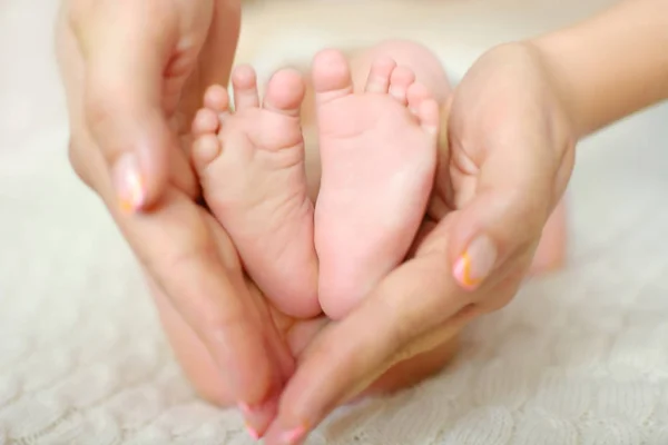 Mano de bebé en la mano de mamá con un fondo borroso — Foto de Stock