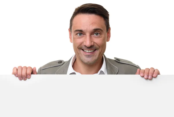 Веселый человек стоит за пустым рекламным щитом — стоковое фото