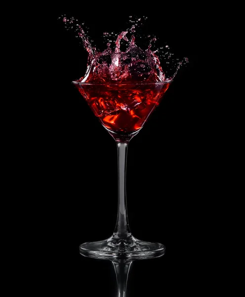 Ice cube dropped into a glass of grape juice — Stock fotografie