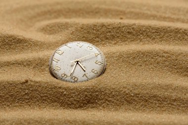 old broken watch on a sand background clipart