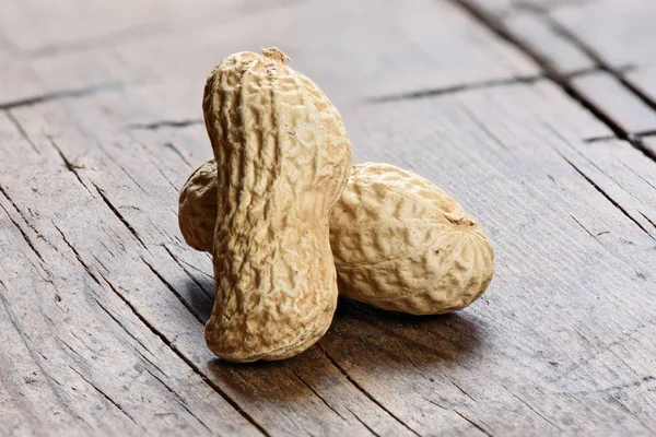 Сырой арахис на деревянном столе — стоковое фото