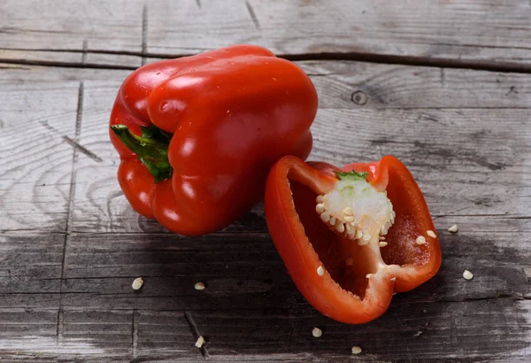 Röd paprika på träbord — Stockfoto