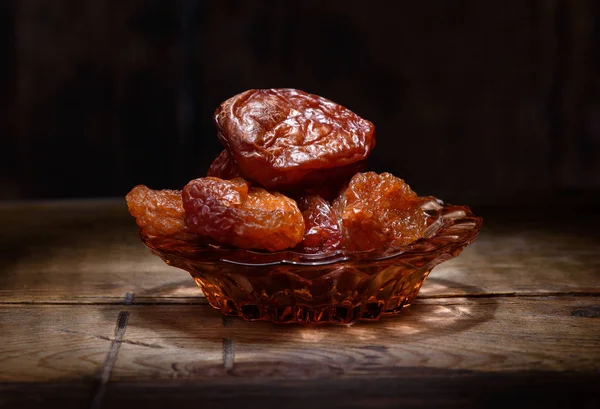 Getrocknete Aprikosen auf dunklem Holz — Stockfoto