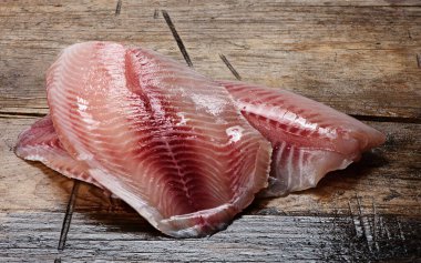 Tilapia fileto ahşap arka plan üzerinde