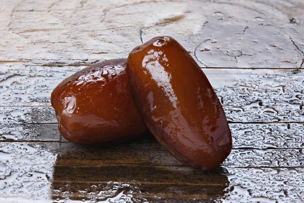 Dates on wet wooden background — Stock Photo, Image