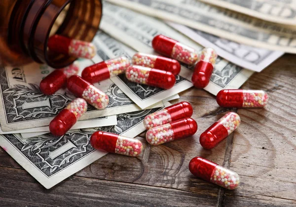Bottle with tablets and money. — Stock Photo, Image