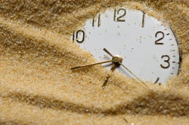 Old clock face in sand clipart