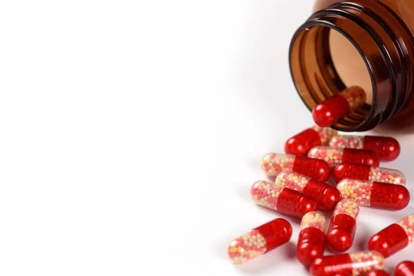 Red medical capsules and bottle isolated — Stock Photo, Image