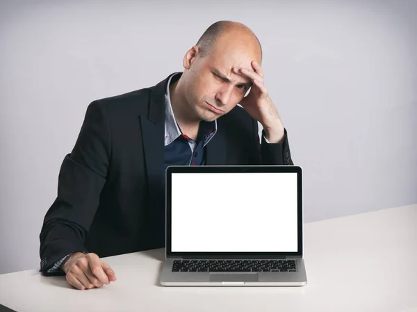 Сердитый лысый бизнесмен с ноутбуком — стоковое фото
