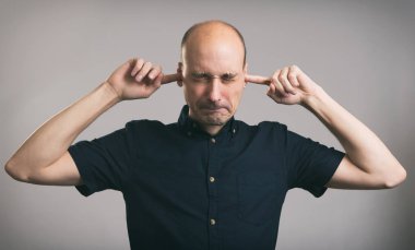 Adam kulaklarını kapatıyor.