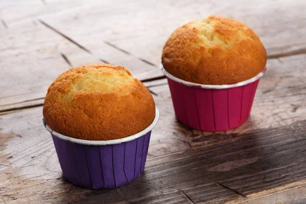 Dois muffins em uma mesa de madeira — Fotografia de Stock