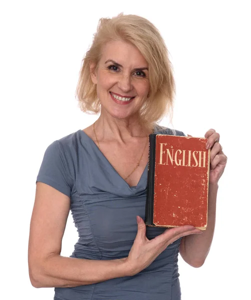 Mogen kvinna håller en engelsk lärobok — Stockfoto