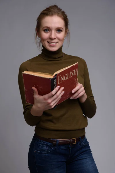 Jovem menina bonita lendo Inglês livro didático — Fotografia de Stock