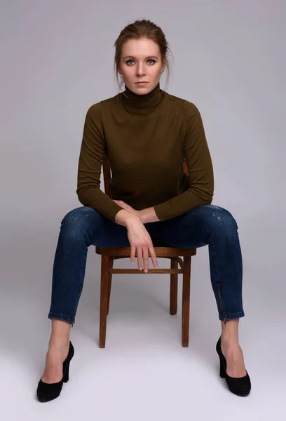 Ładna kobieta siedzi na krześle — Zdjęcie stockowe