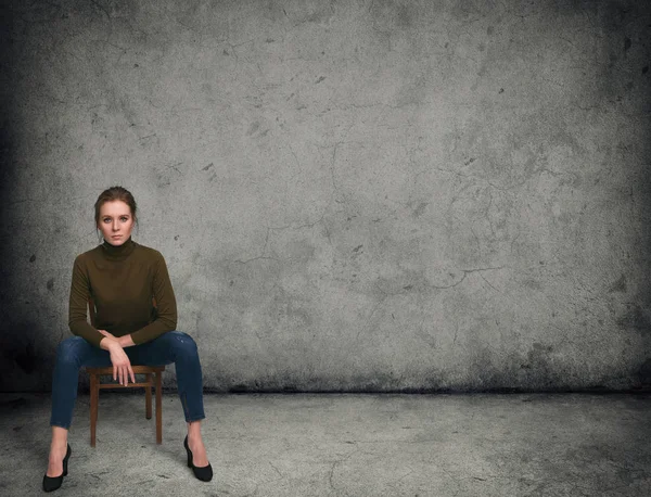 Красивая женщина сидит на стуле Стоковое Фото