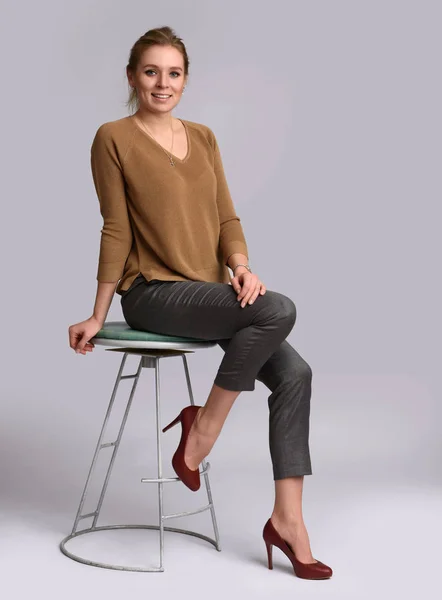 Leende kvinna sitter på stol — Stockfoto