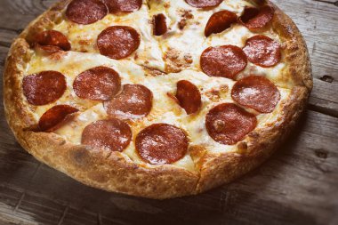 ahşap masa üstünde pepperoni pizza