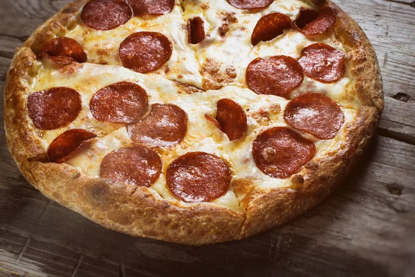 Ahşap masa üstünde pepperoni pizza — Stok fotoğraf