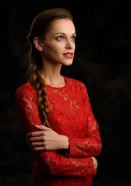 Красивая женщина с косой в красном платье — стоковое фото