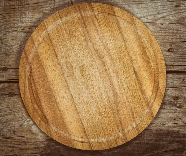 Old cutting board on a wooden table — Stock Photo, Image