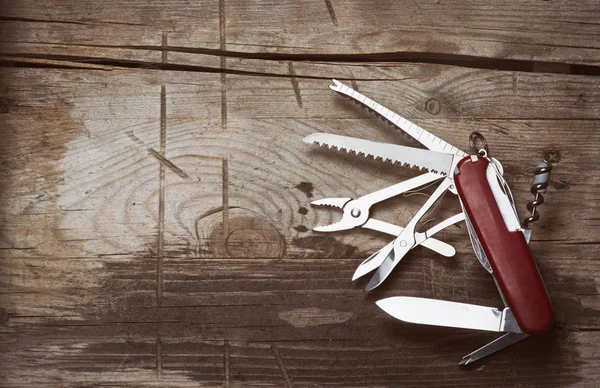 Starý švýcarský nůž na dřevěné pozadí — Stock fotografie