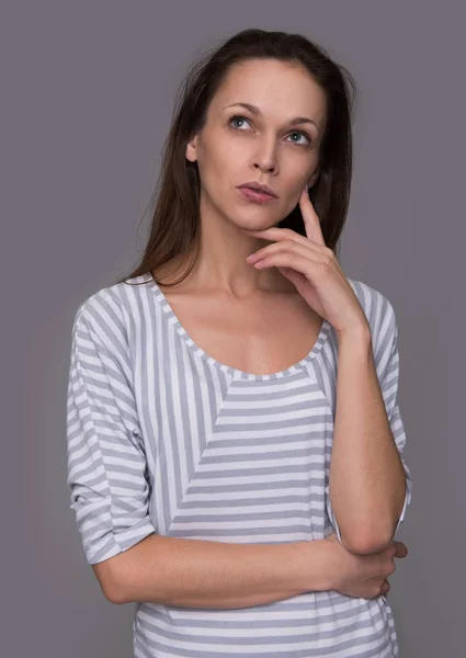 Mujer casual mirando hacia arriba y pensando — Foto de Stock