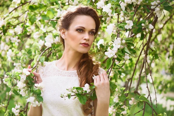 美丽的女人，开花的春天树附近 — 图库照片