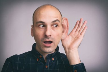 gizli bir konuşma dinlemek çalışan adam