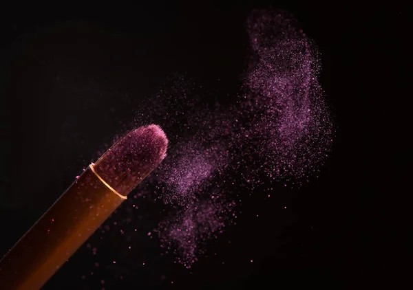 Makeup brush with pink powder explosion — Stock Photo, Image