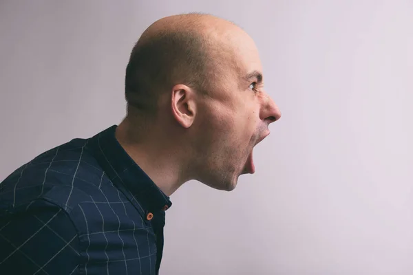 Vista lateral de um homem careca bonito gritando — Fotografia de Stock