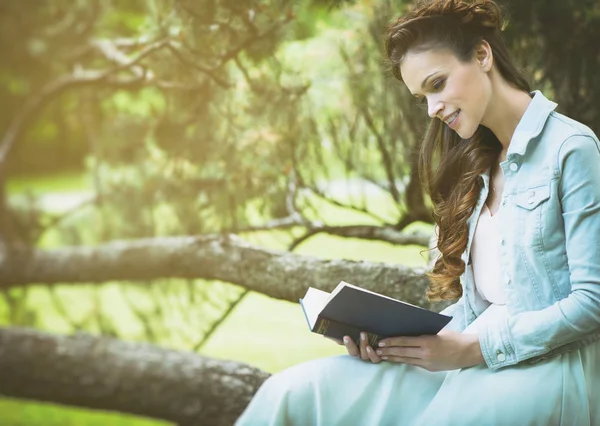 Ragazza nel parco che legge un libro — Foto Stock