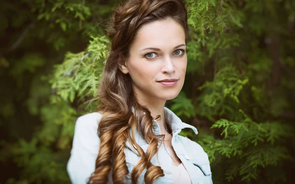Ung vacker kvinna med långt hår i parken — Stockfoto