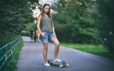 Kaykay ile güzel genç kadın