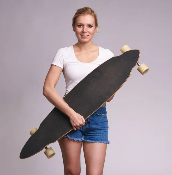Beautiful young woman holds her longboard — Stock Photo, Image
