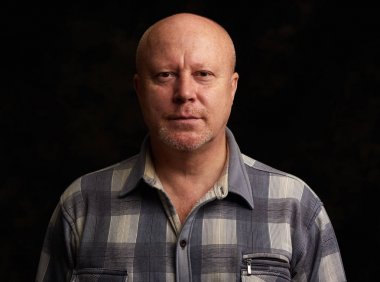 siyah arka plan üzerinde yaşlı kel adam