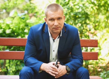 Adam şehir parkta bir bankta oturur