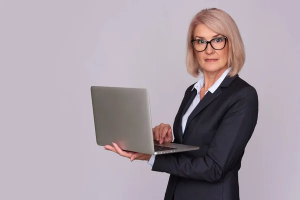 Mujer de mediana edad que trabaja en el ordenador portátil —  Fotos de Stock
