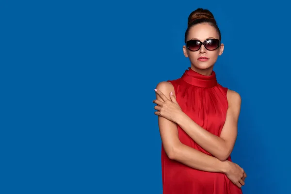 Güneş gözlüğü takmış Kırmızı elbiseli seksi kadın — Stok fotoğraf