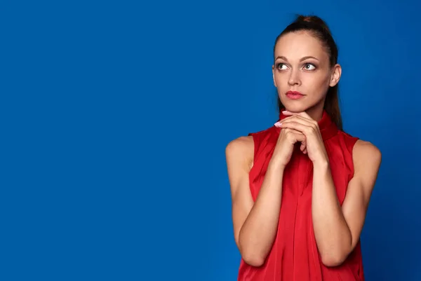 Sad girl in red dress on blue background — Stock Photo, Image
