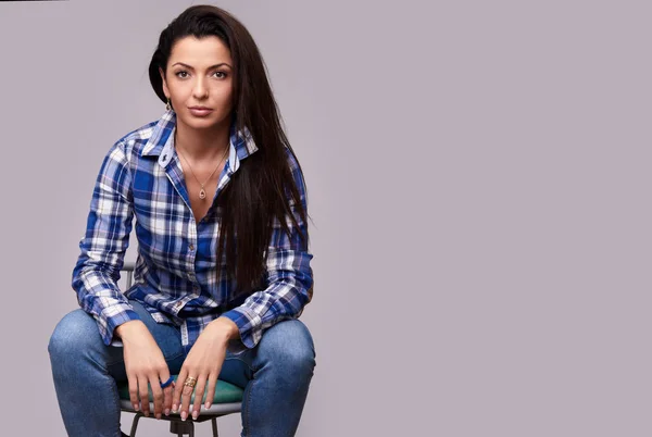Trendy casual woman sitting on a chair. Isolated — Stock Photo, Image