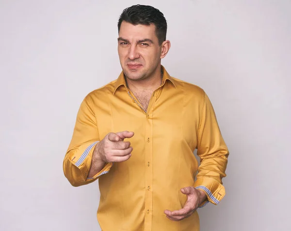 Hombre con camisa amarilla apuntándote — Foto de Stock