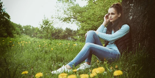 Bella donna seduta vicino all'albero — Foto Stock